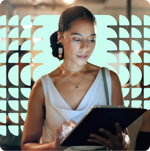 A woman in a white sleeveless top uses a tablet for day of planning and event execution. She is in an indoor setting with a patterned light display in the background.