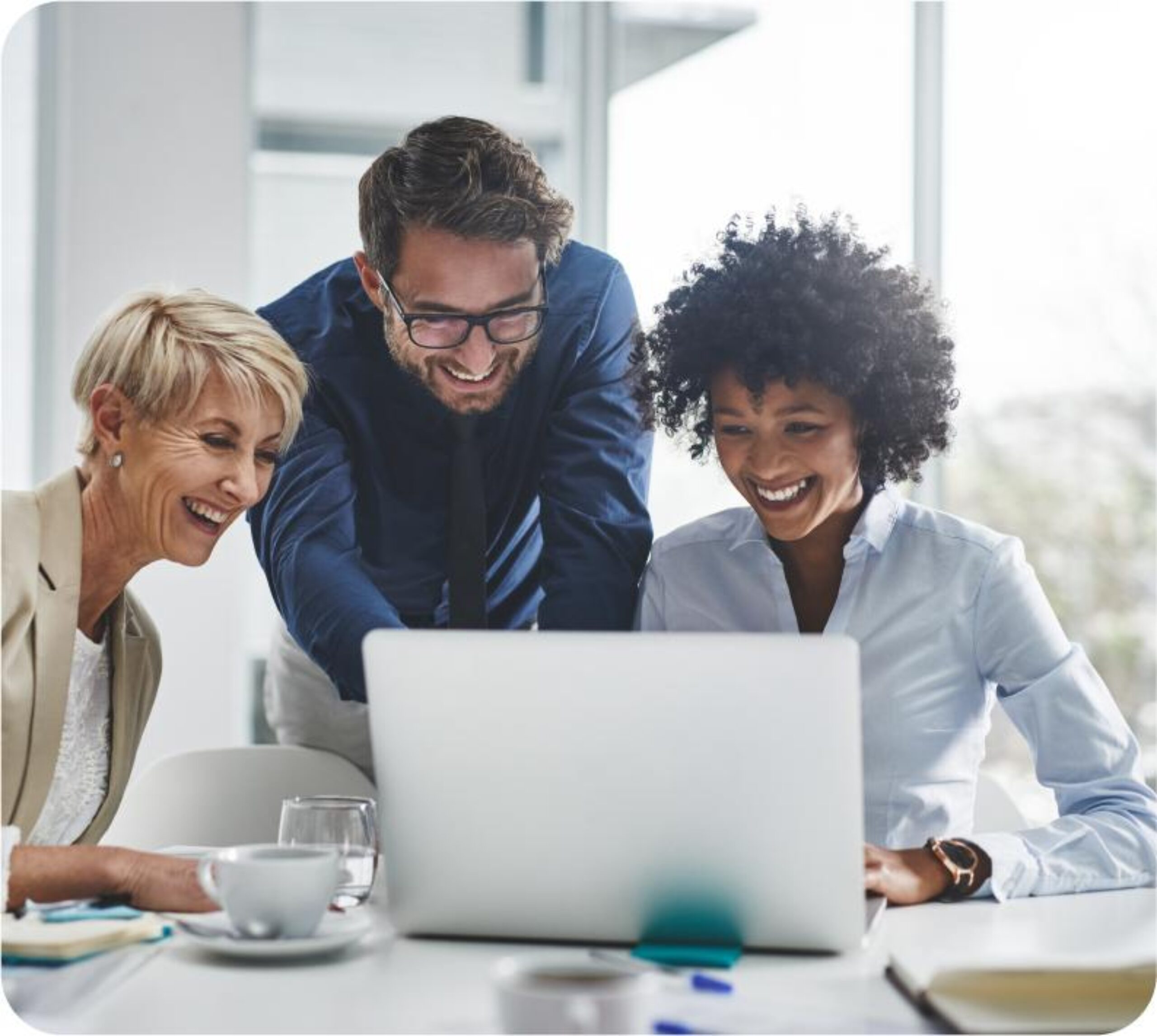 Corporate event planner team smile while they look at what they can do with Prismm on a shared laptop.