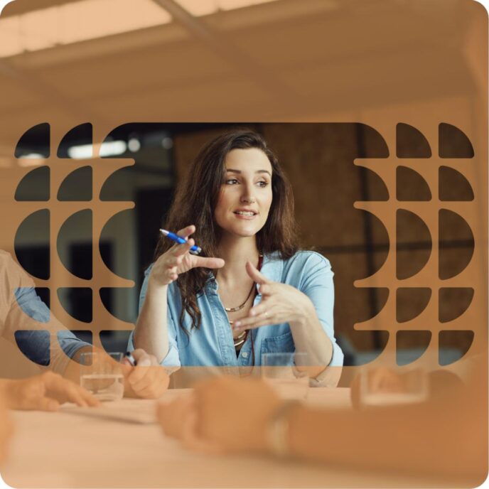 In an ownership group company meeting, a woman in a blue shirt gestures while explaining the value of dynamic 3D layouts.