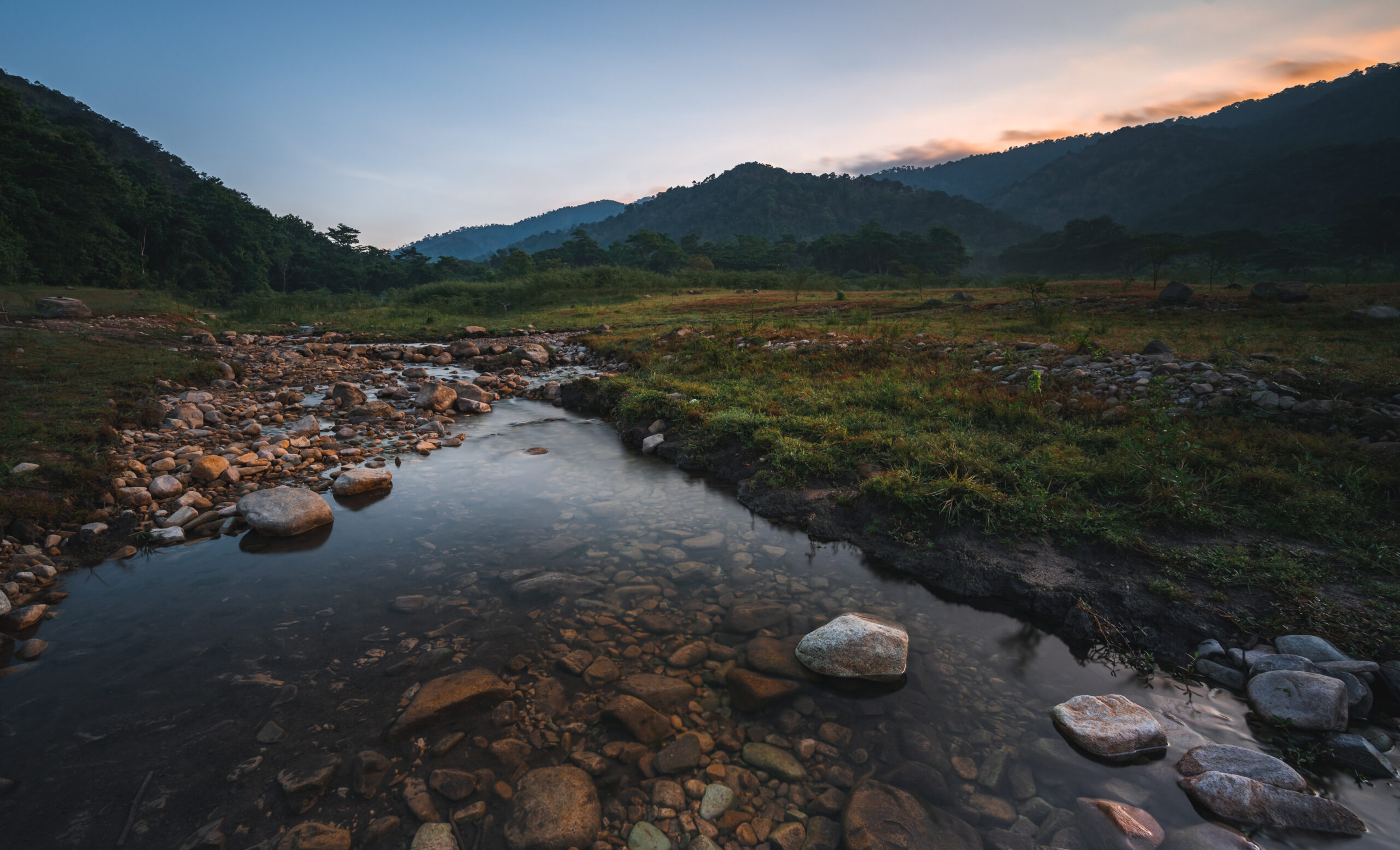 Nature landscape view of fresh water stream with the background of mountain and forest. Image by https://www.vecteezy.com/members/ck-stockphoto