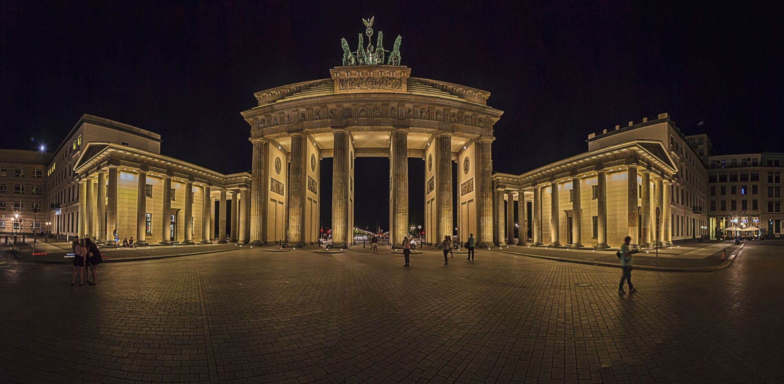 Photograph in the background. It is a night view over Paris square to illuminated Brandenburger gate in Berlin