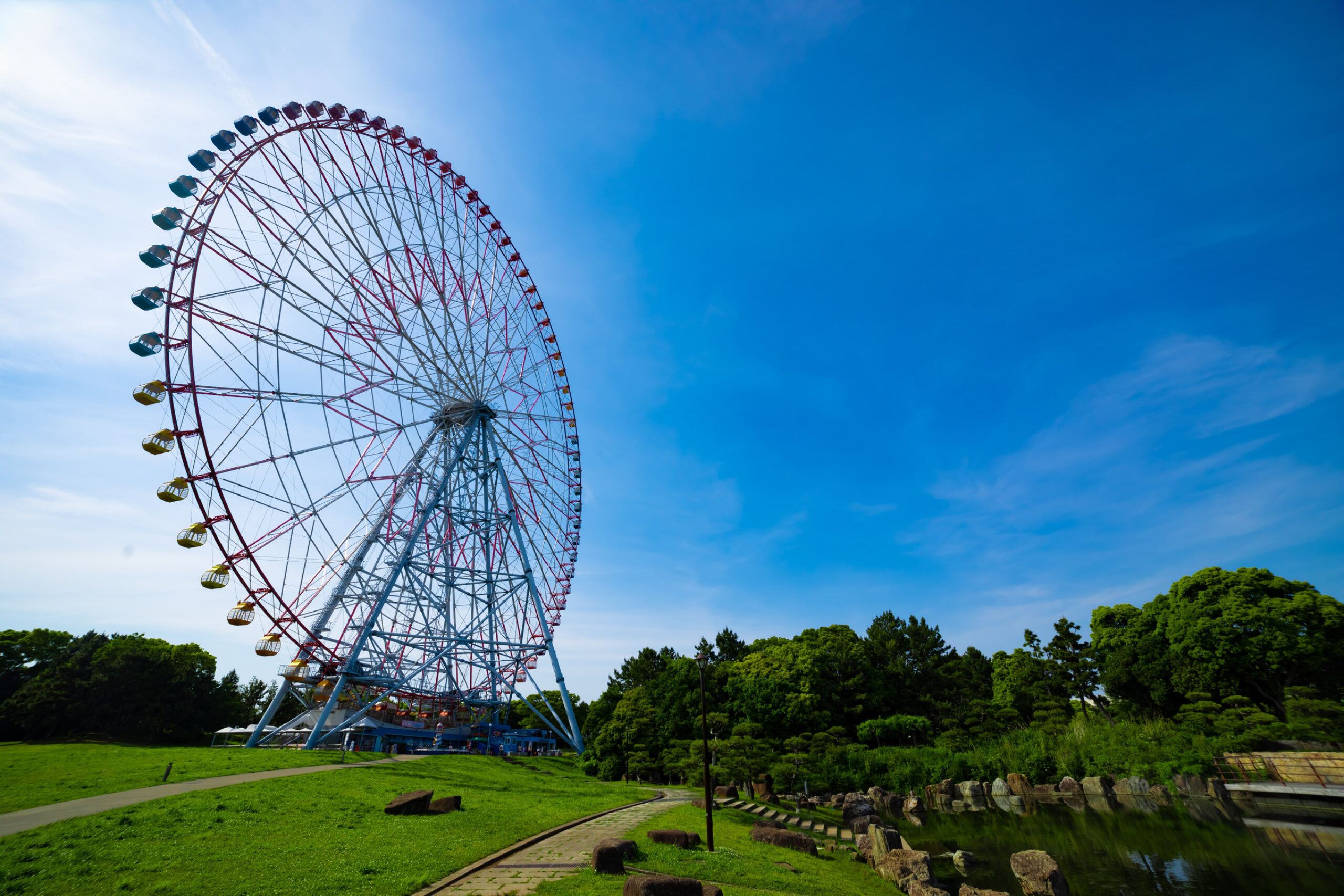 Attraction photograph of a ferris wheel at the park. The picture uses a blue sky wide shot. High quality photo. Edogawa district Rinkaicho, Tokyo, Japan 05.10.2023. It is ferris wheel in Tokyo.